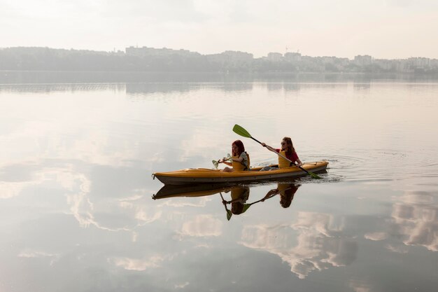 Mujeres de tiro largo remando en kayak