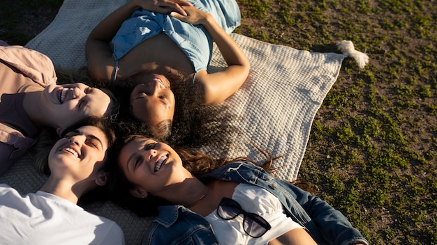 Mujeres de tiro medio acostadas en la hierba