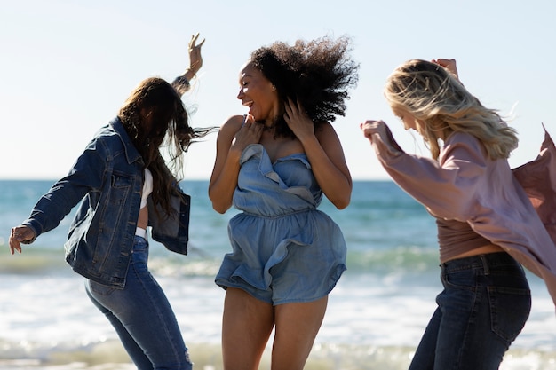 Mujeres de tiro medio bailando en la playa