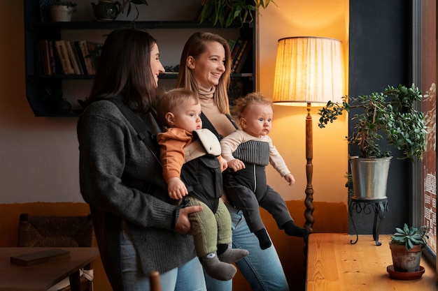 Mujeres de tiro medio con bebés en portabebés