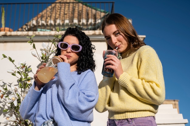 Foto gratuita mujeres de tiro medio bebiendo kombucha