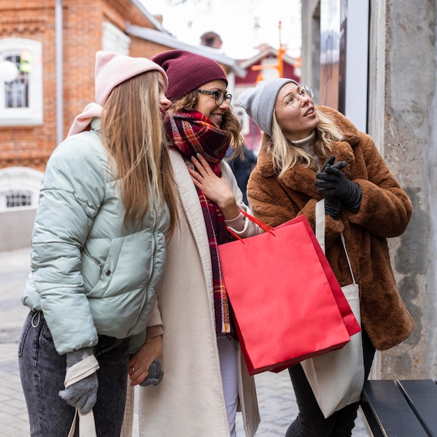 Mujeres de tiro medio con bolsas de la compra.