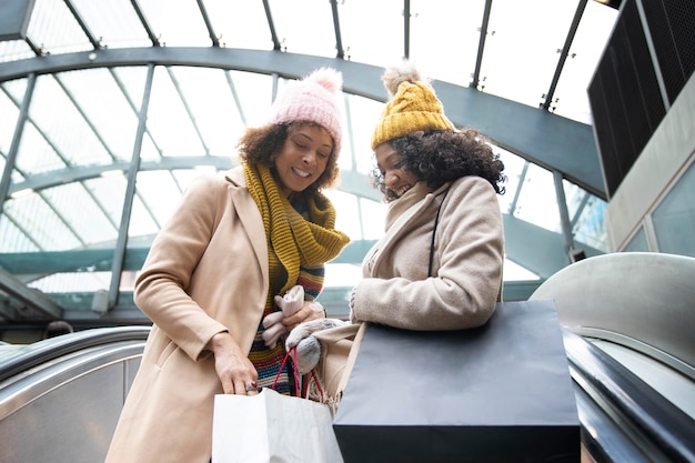 Mujeres de tiro medio con bolsas de la compra.