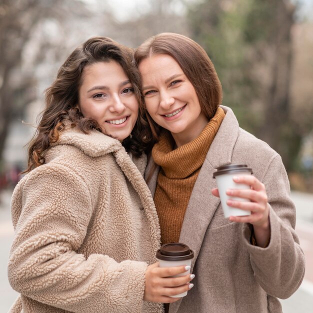 Mujeres de tiro medio con café al aire libre