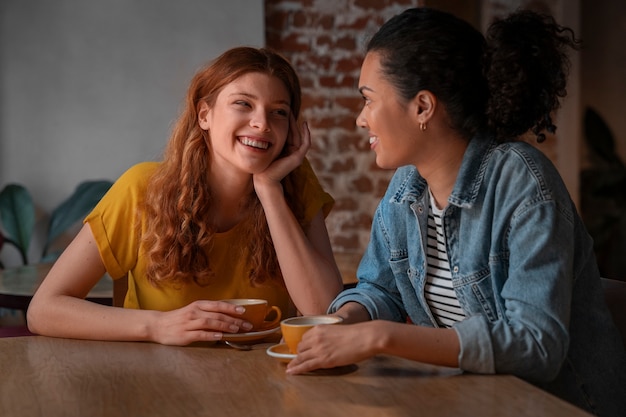 Mujeres de tiro medio en cafetería.