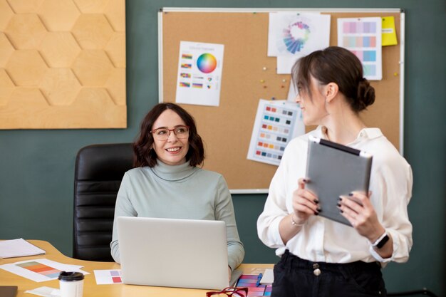 Mujeres de tiro medio chateando en el trabajo