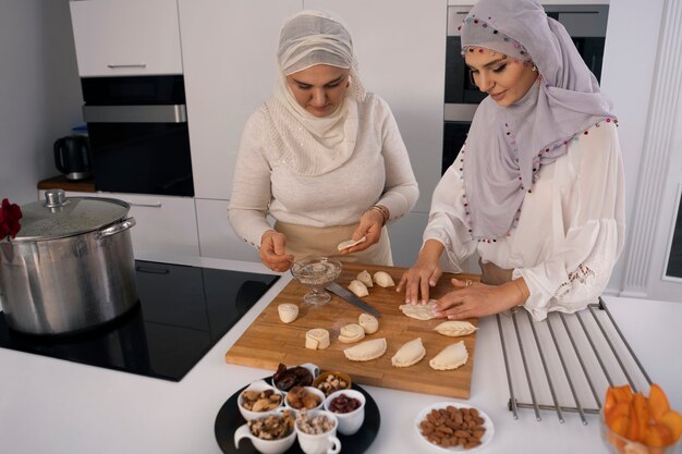 Mujeres de tiro medio cocinando para el ramadán