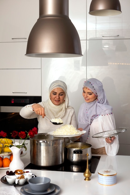 Mujeres de tiro medio cocinando para el ramadán