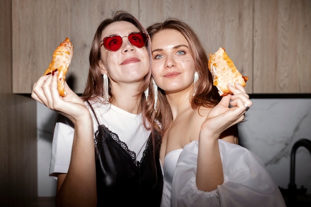 Mujeres de tiro medio con comida deliciosa.