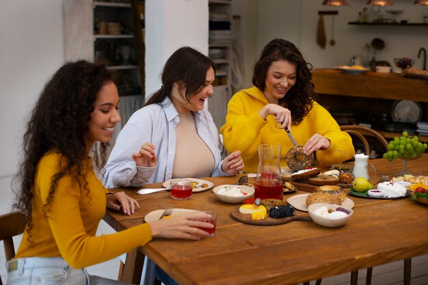 Mujeres de tiro medio con comida deliciosa