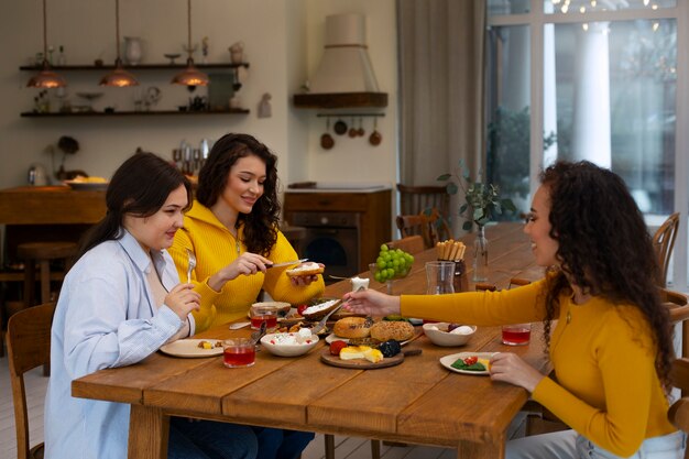 Mujeres de tiro medio con comida deliciosa