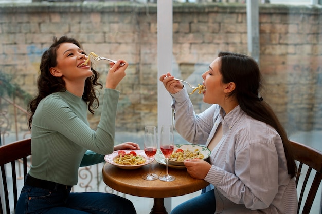 Mujeres de tiro medio con comida deliciosa