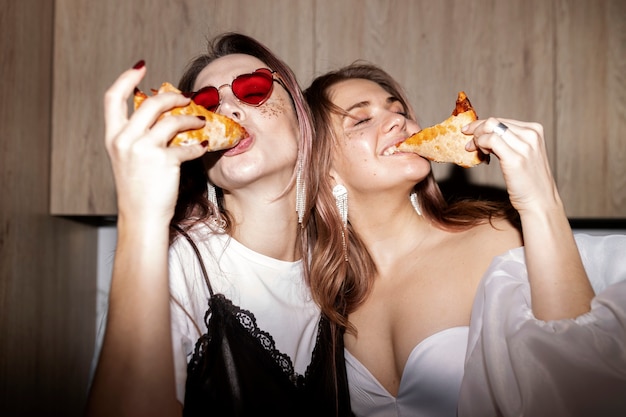 Mujeres de tiro medio comiendo comida deliciosa