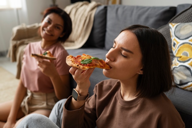 Mujeres de tiro medio comiendo deliciosa pizza