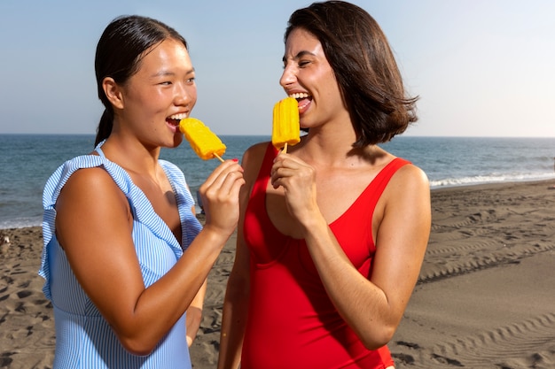 Mujeres de tiro medio comiendo helado