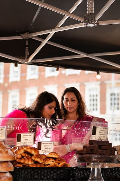 Foto gratuita mujeres de tiro medio comprando pasteles