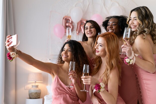 Mujeres de tiro medio en despedida de soltera tomando selfie