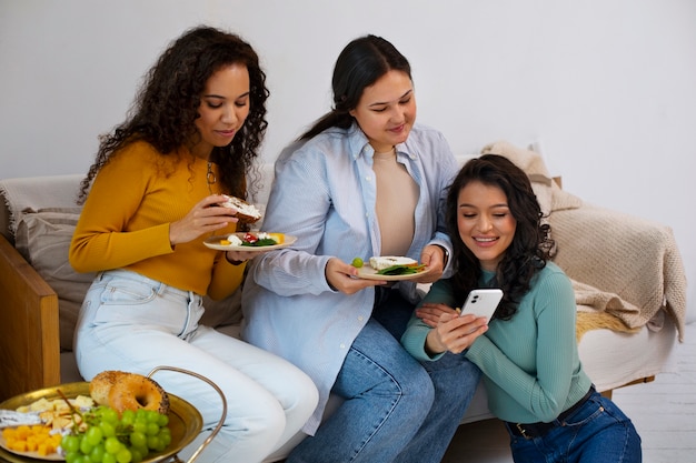 Mujeres de tiro medio disfrutando de una deliciosa comida.