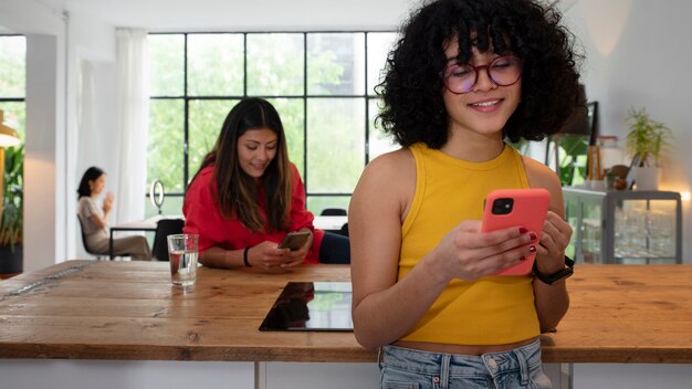 Mujeres de tiro medio con dispositivos en interiores.