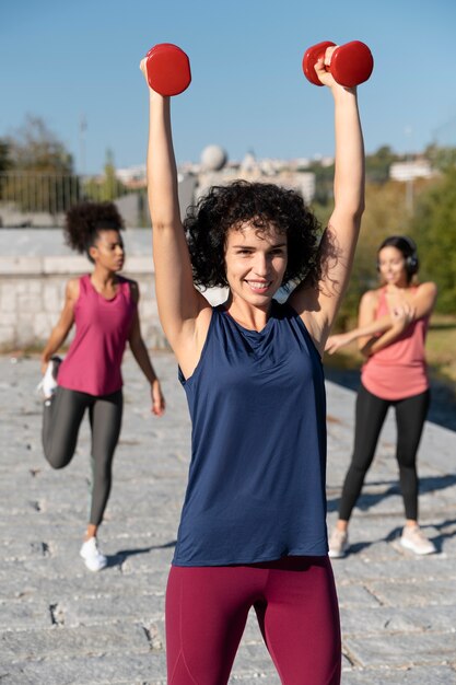 Mujeres de tiro medio entrenando al aire libre