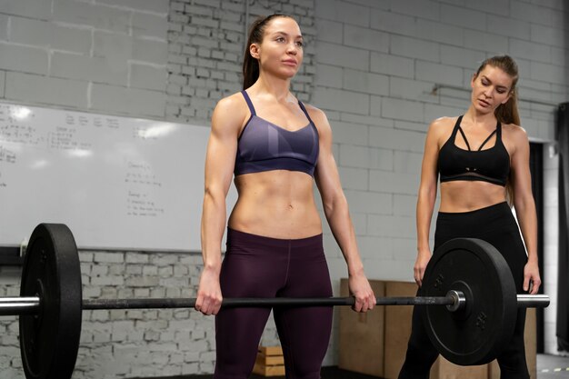 Mujeres de tiro medio entrenando en el gimnasio