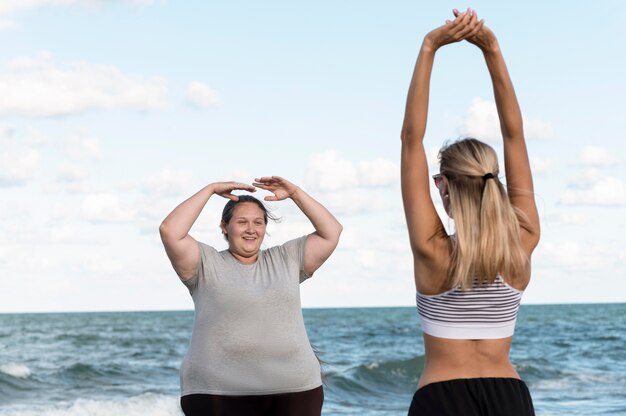 Mujeres de tiro medio estirando