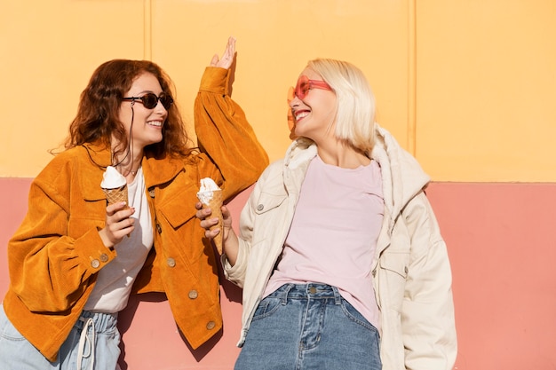 Mujeres de tiro medio con helado