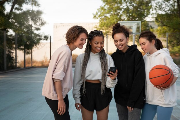 Mujeres de tiro medio jugando baloncesto