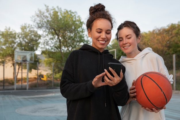 Mujeres de tiro medio jugando baloncesto