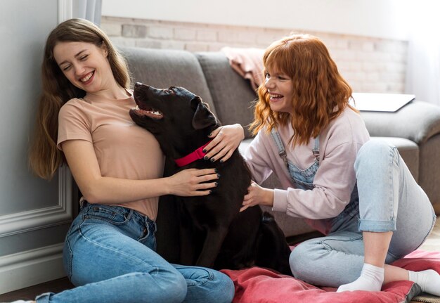 Mujeres de tiro medio jugando con perro