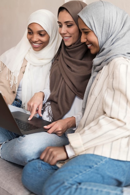 Mujeres de tiro medio con laptop