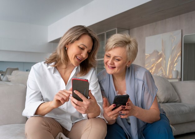 Mujeres de tiro medio leyendo mensajes de celular