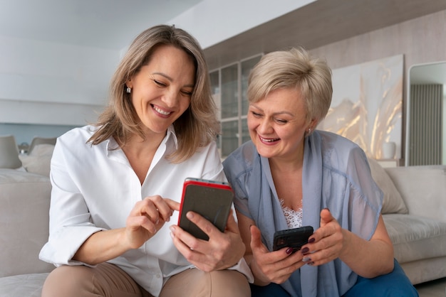 Mujeres de tiro medio leyendo mensajes de celular