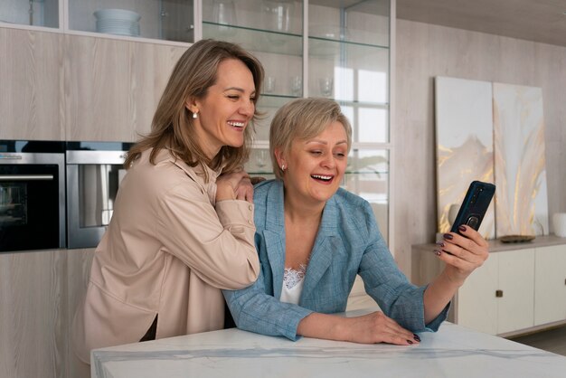 Mujeres de tiro medio leyendo mensajes de celular