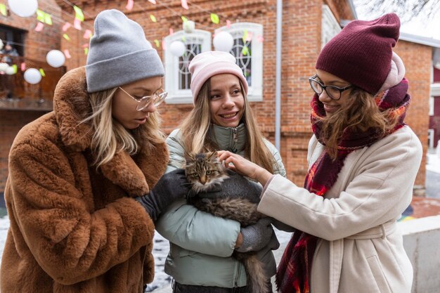 Mujeres de tiro medio con lindo gato