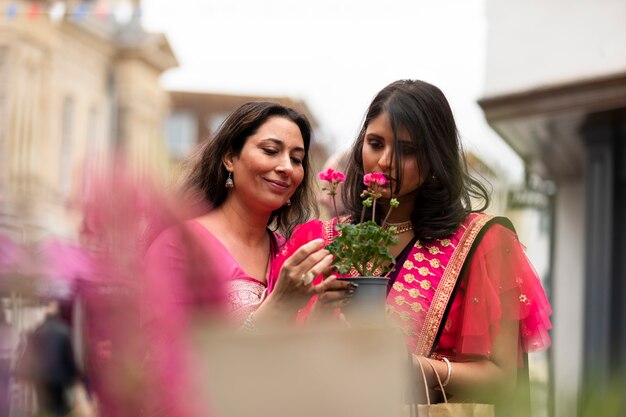 Mujeres de tiro medio oliendo flores.