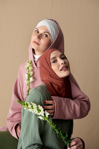 Mujeres de tiro medio posando con flores