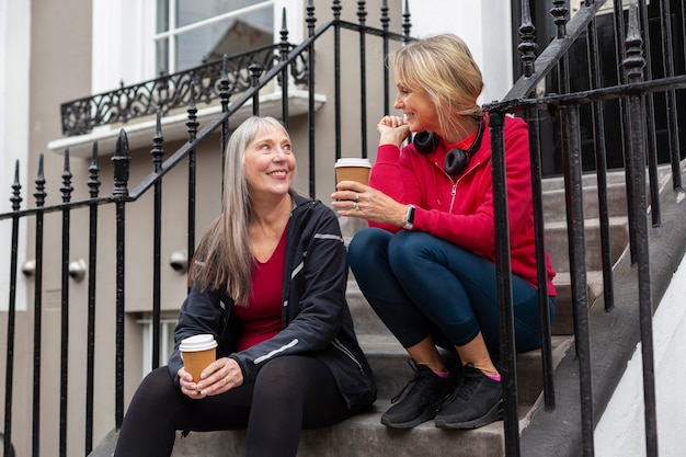 Mujeres de tiro medio sentadas juntas