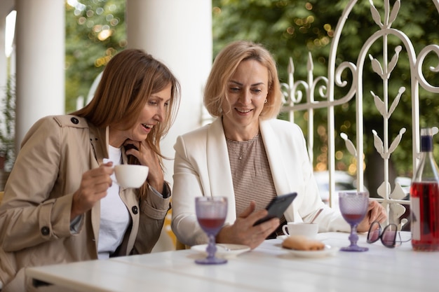 Mujeres de tiro medio con smartphone