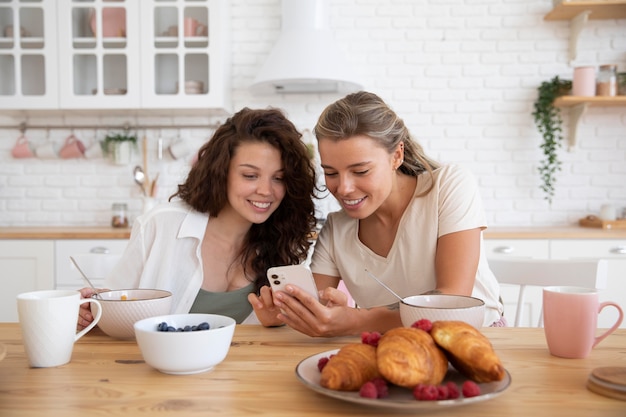 Mujeres de tiro medio con smartphone