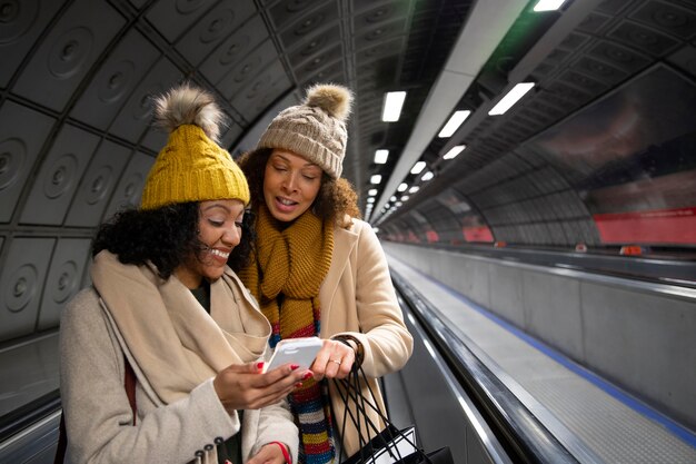 Mujeres de tiro medio con smartphone