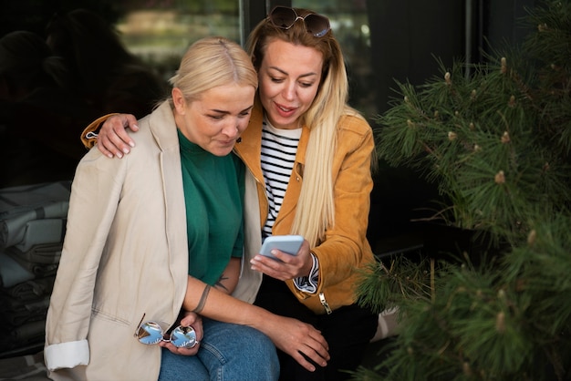 Mujeres de tiro medio con smartphone