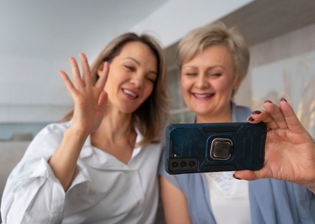 Foto gratuita mujeres de tiro medio con smartphone