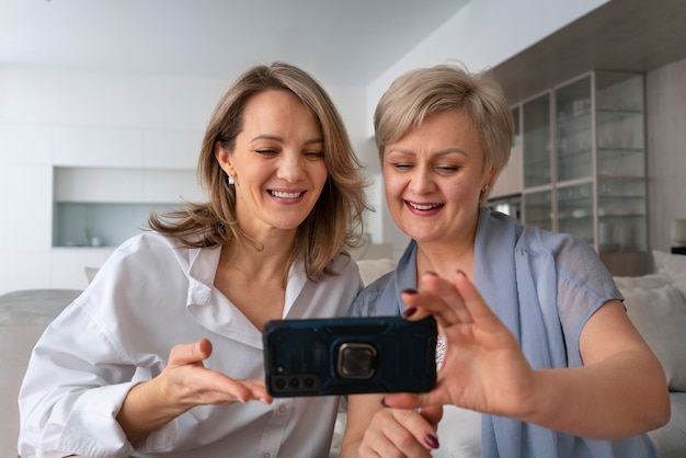 Foto gratuita mujeres de tiro medio con smartphone