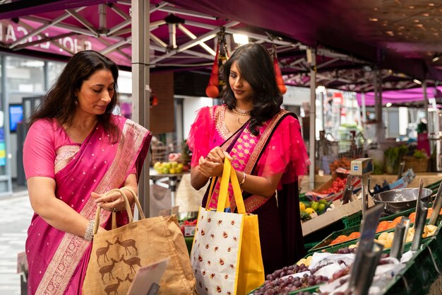 Mujeres de tiro medio sosteniendo bolsas de la compra.