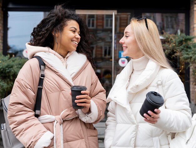 Mujeres de tiro medio con tazas de café