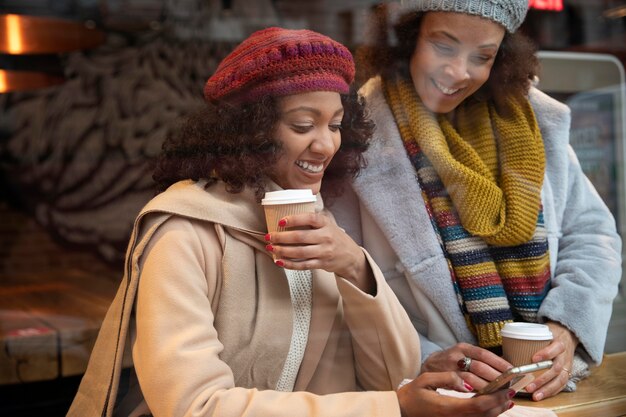 Mujeres de tiro medio con tazas de café