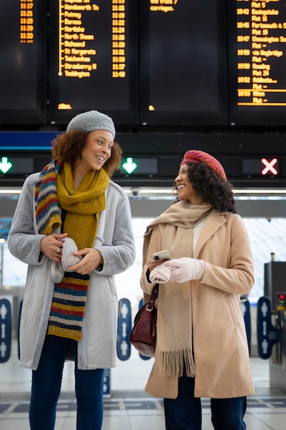 Mujeres de tiro medio en la temporada de invierno del aeropuerto