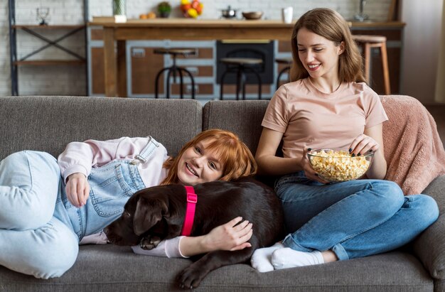 Mujeres de tiro medio tendido con perro