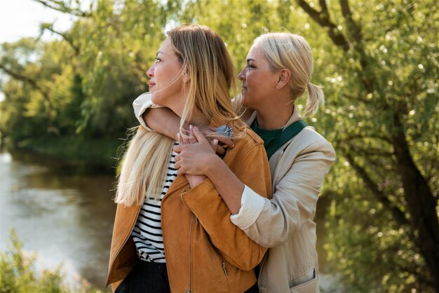 Mujeres de tiro medio tomados de la mano